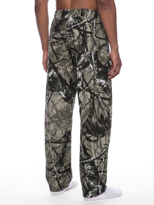 STILL. Unisex Tree Camo Barrel Leg Pants, worn by a model