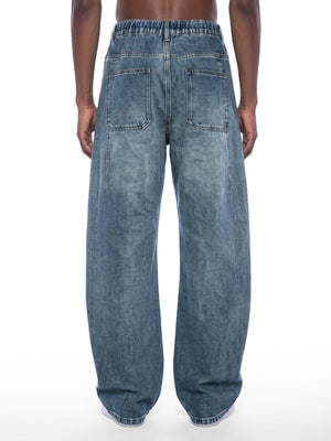 STILL. Unisex Vintage Wash Barrel Leg Jeans, worn by a model
