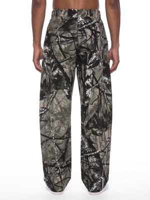 STILL. Unisex Tree Camo Barrel Leg Pants, worn by a model